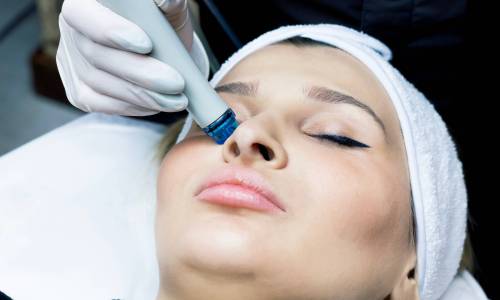 Face cleansing procedure close-up, deep serum vacuum hydro-peeling. Young woman enjoys a radiant face in a beauty salon, facial skincare cosmetologist, beautician, modern technologies